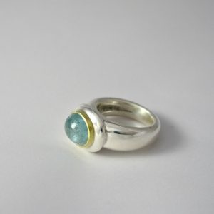 Aquamarine set in gold on heavy oval silver button and a chunky silver shank