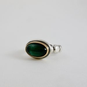 Deep viridian green oval tourmaline set in gold on a silver ball ring