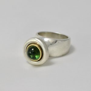 round cabochon Green tourmaline set in gold on chunky silver plinth ring