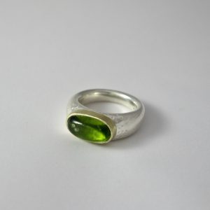 oval peridot in gold setting on silver chunky plain ring