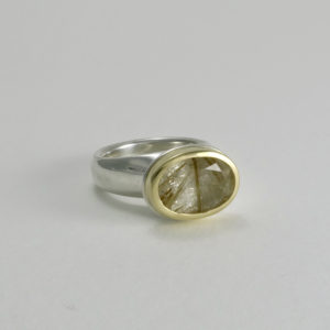 Rutilated quartz in gold setting on silver plinth ring