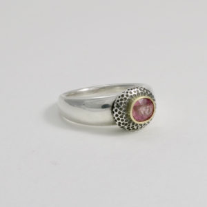 peachy pink faceted sapphire with gold setting in unusual solid silver ring